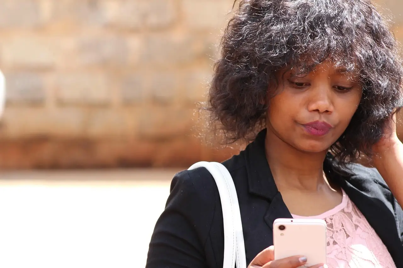 Personne qui lit un message sur son téléphone, l'air préoccupé